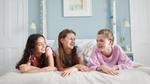 Drie gelukkige meisjes in een slaapkamer.